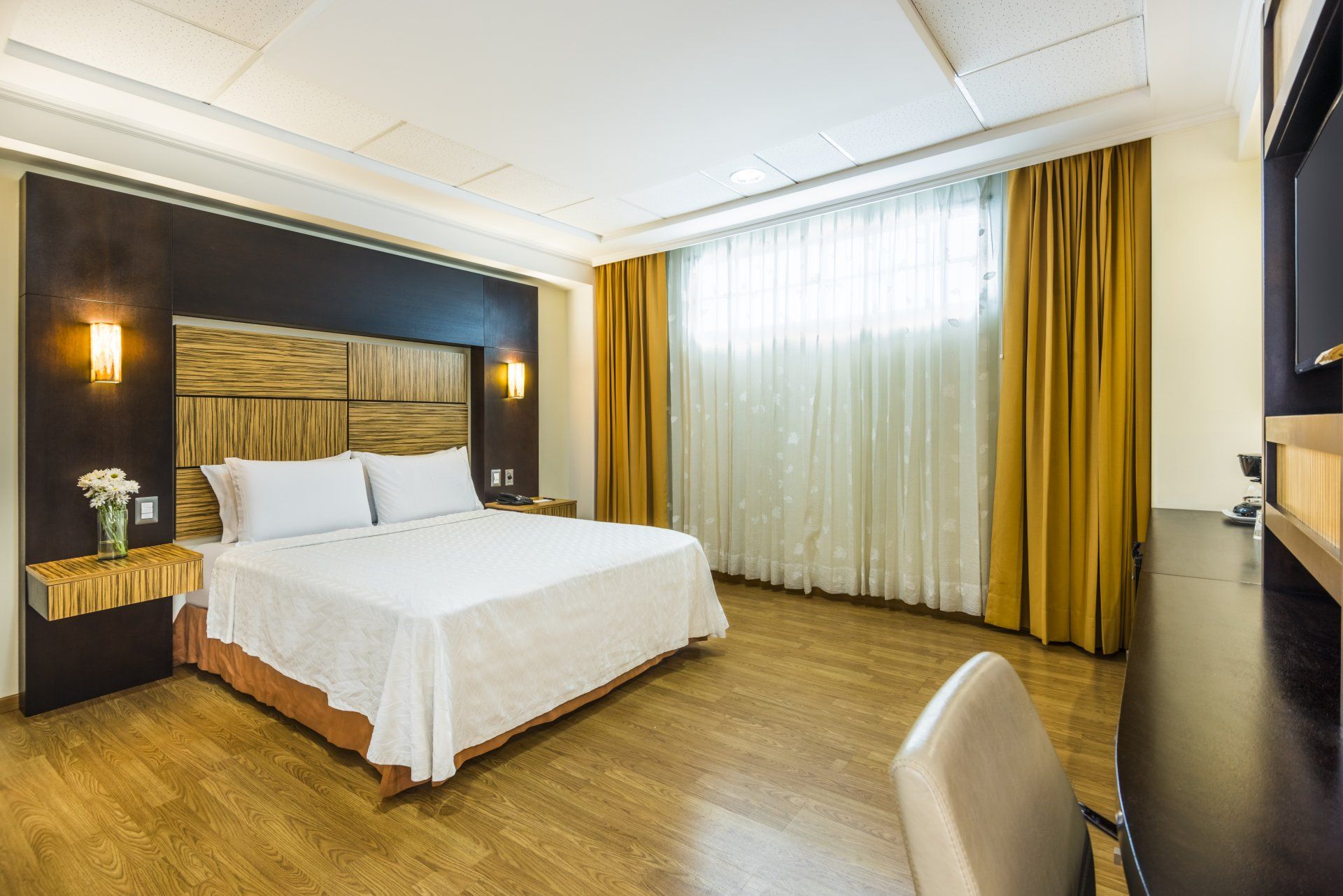 Una habitación de hotel con una cama tamaño king y un escritorio