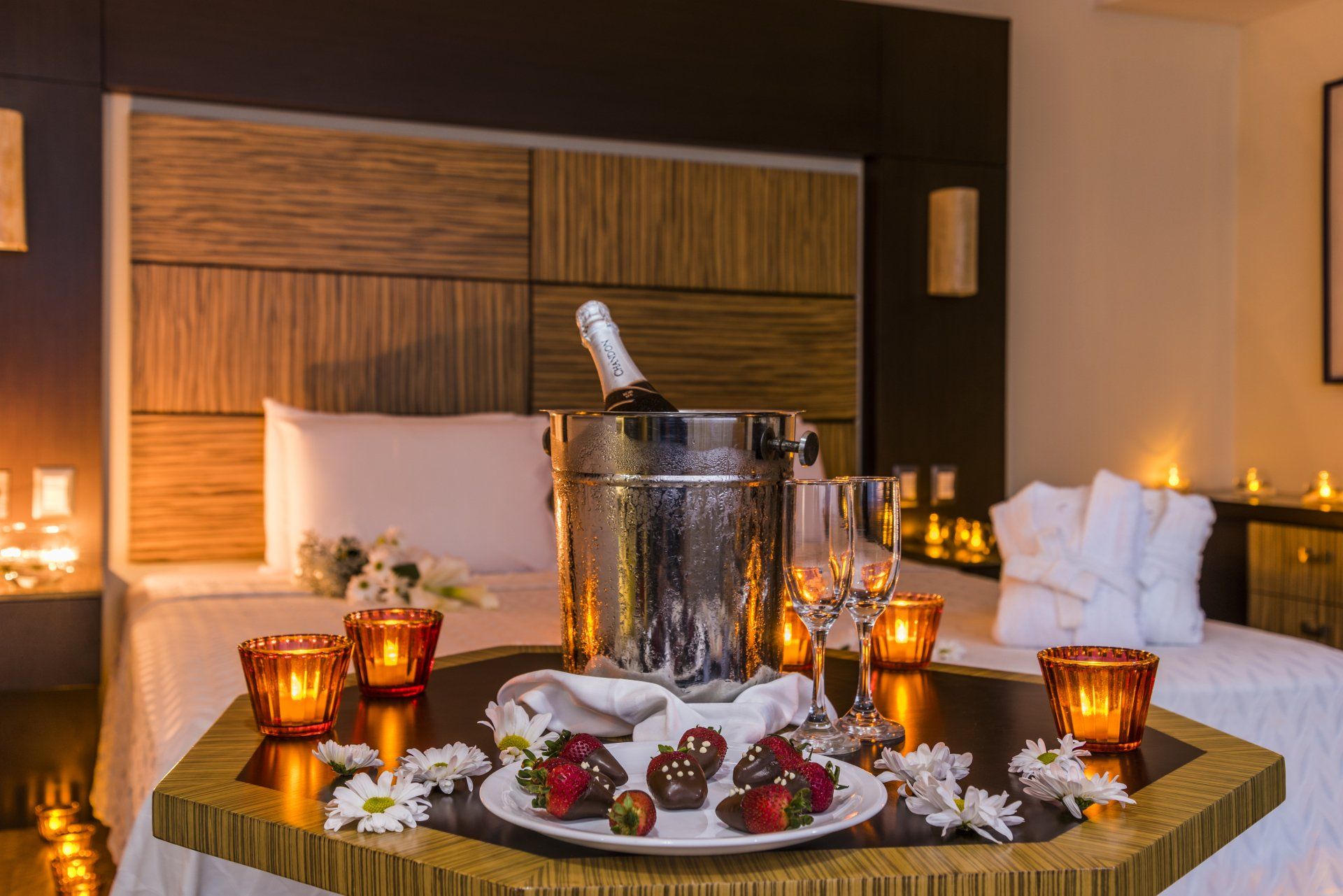 Una habitación de hotel con una mesa preparada para una cena romántica