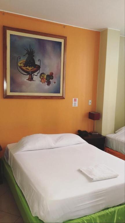 Un dormitorio con una cama y un cuadro en la pared