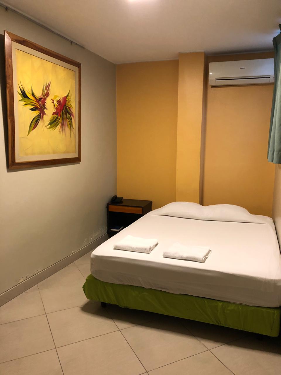 Un dormitorio con una cama y una pintura en la pared