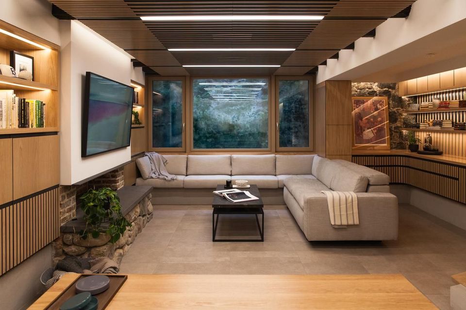 A living room with a large sectional couch and a flat screen tv.