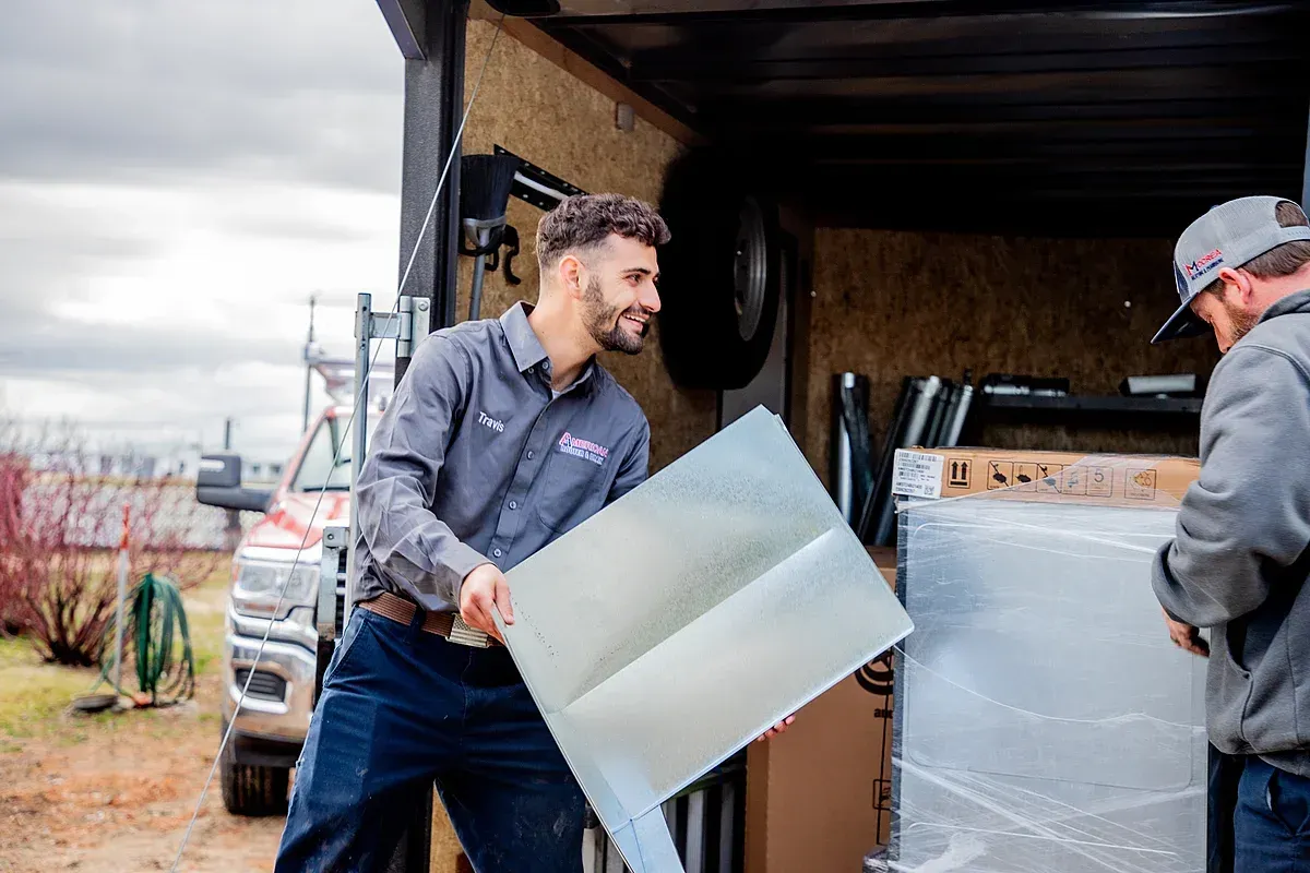 HVAC furnace parts being unloaded from American Rooter & Drain trailer