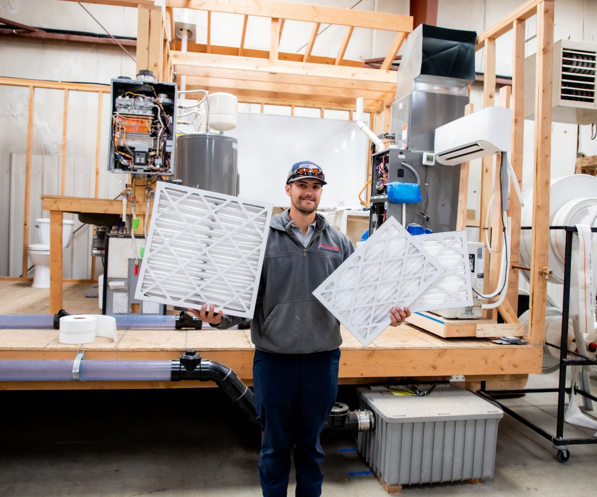 HVAC Technician holding up new air filters for an HVAC system.