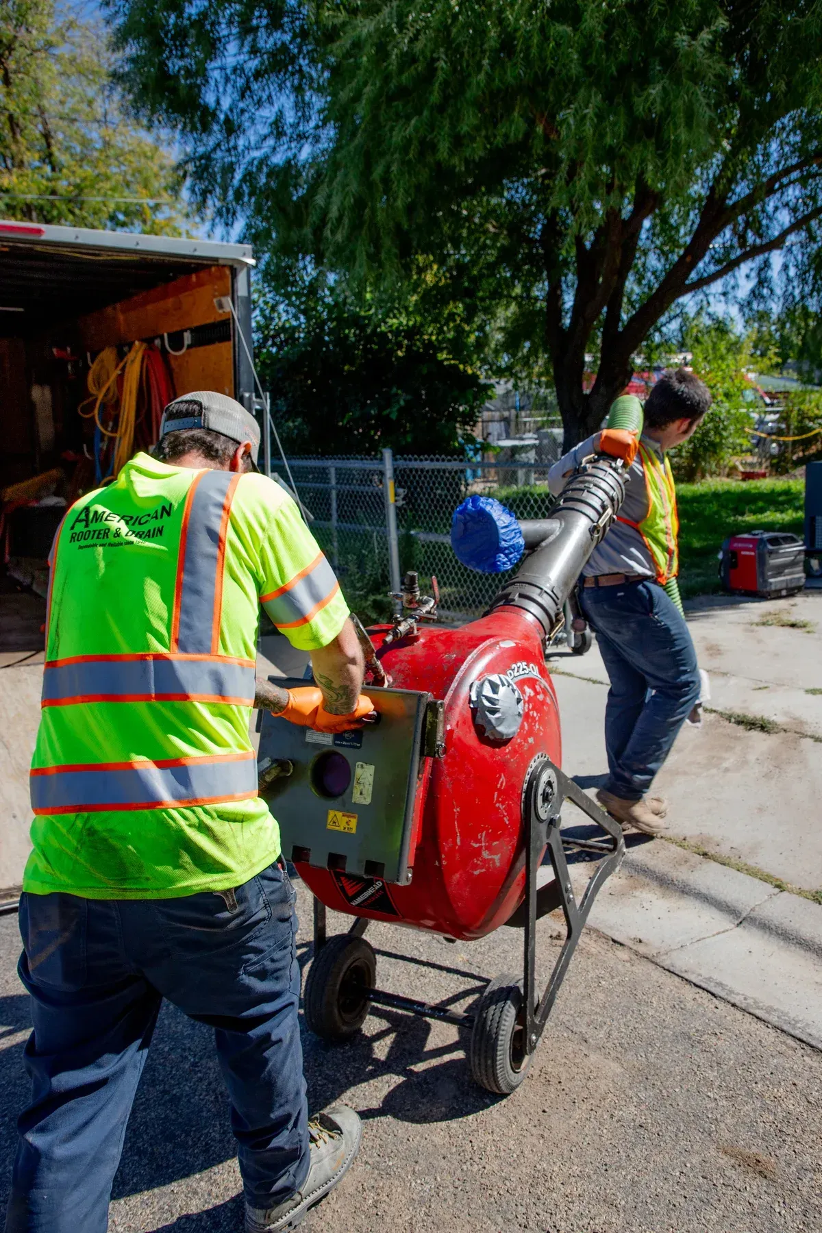 Techs unloading pipe replacement equipment from work trailer