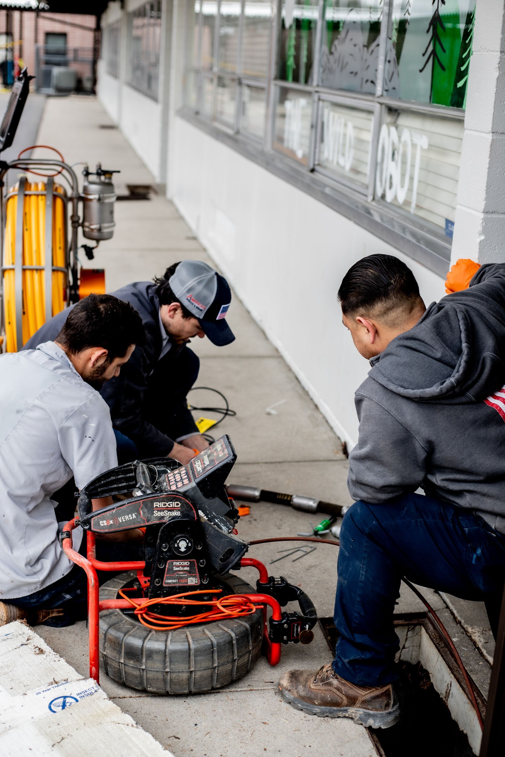 Drain technicians and underground plumbing crew working an elementary school to replace busted pipes