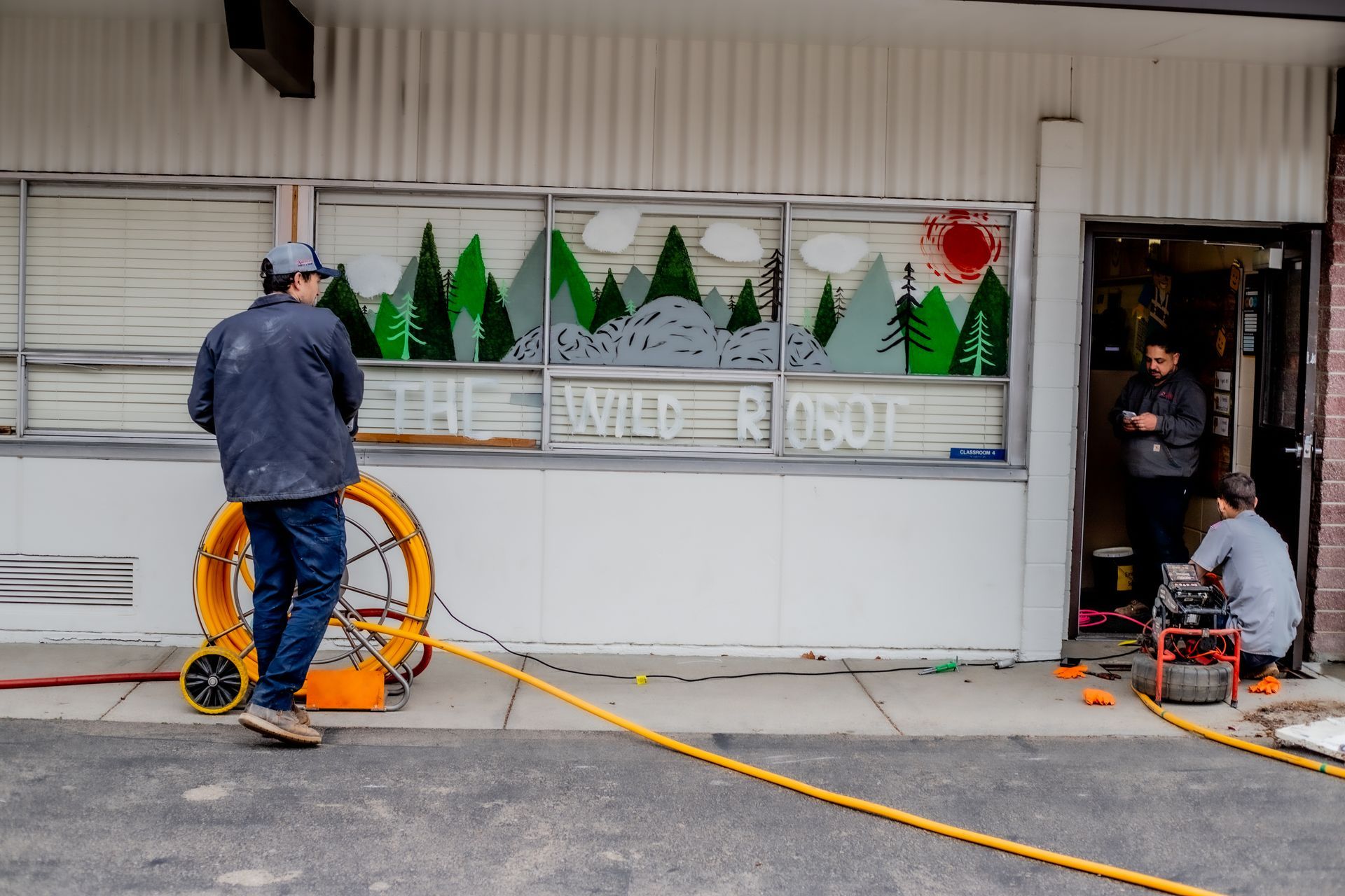 Drain technicians and underground plumbing crew working an elementary school to replace busted pipes