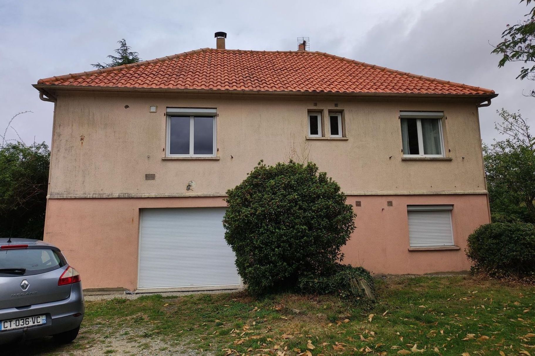 Une maison avec une voiture garée devant
