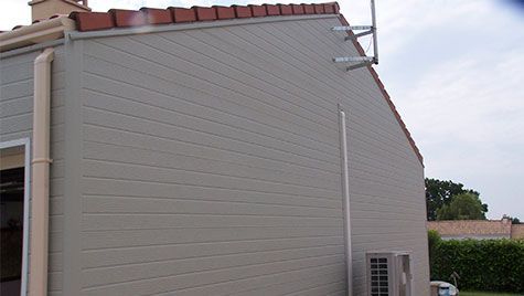 Le côté d'une maison avec une cheminée sur le toit.