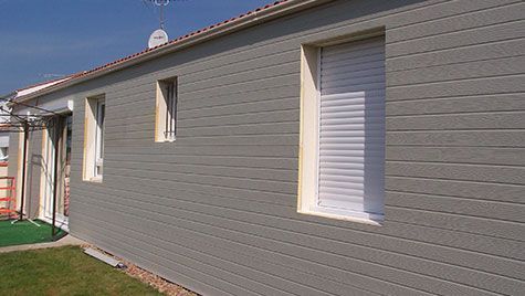 Une maison avec beaucoup de fenêtres sur le côté.