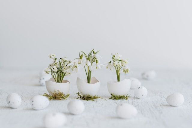 Simple vase with soft pink flowers beside white candle, funeral homes Bainbridge Island, WA