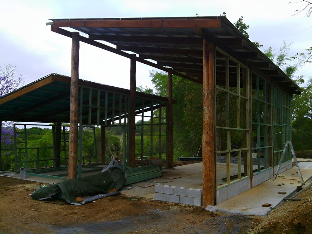 A Wooden Structure With A Roof Is Being Built — Lawrence Williams Fencing in Goolmangar, NSW