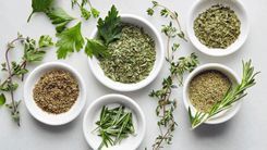 There are many different types of herbs in the bowls.