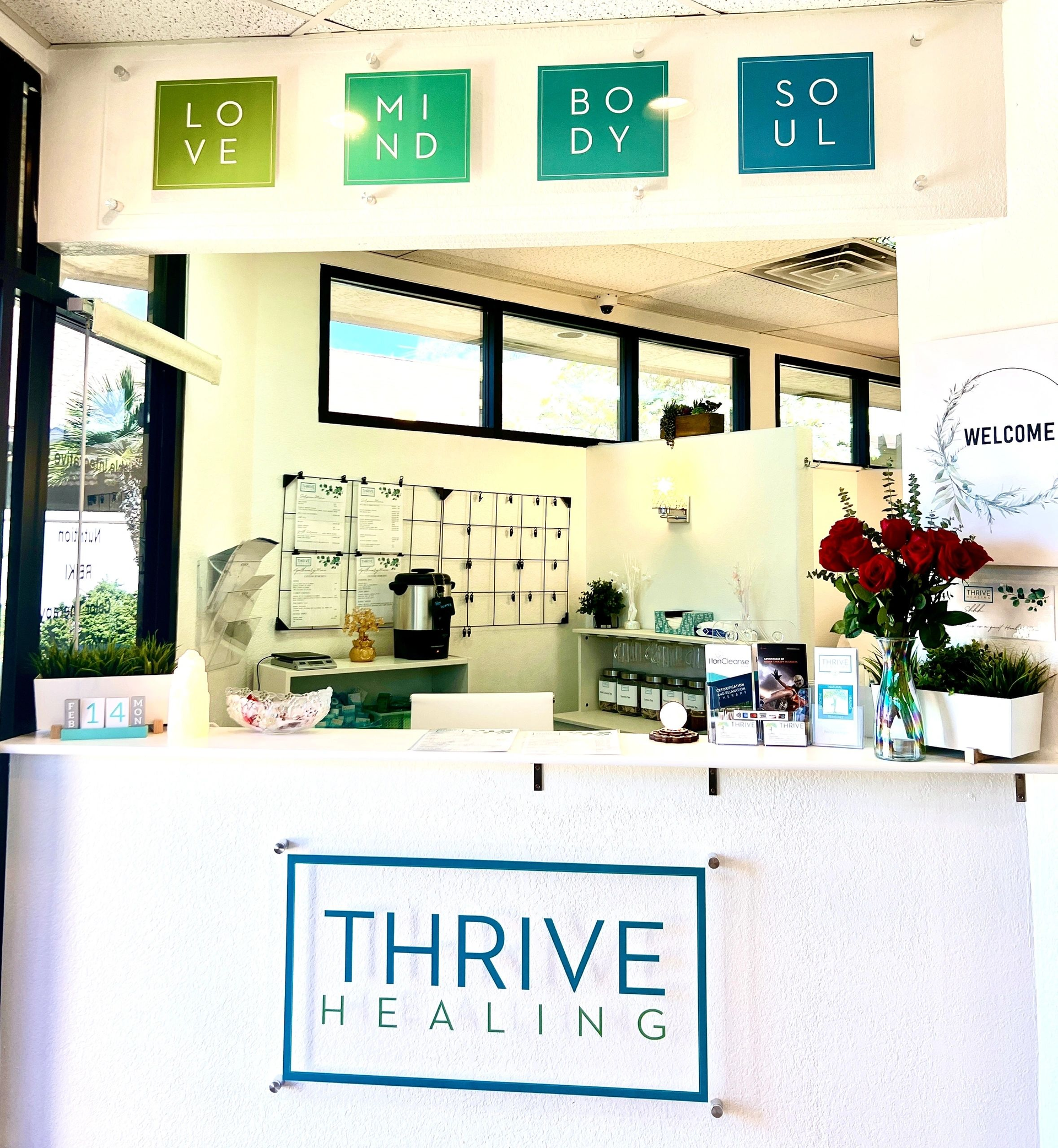 A white counter with a sign that says thrive healing on it