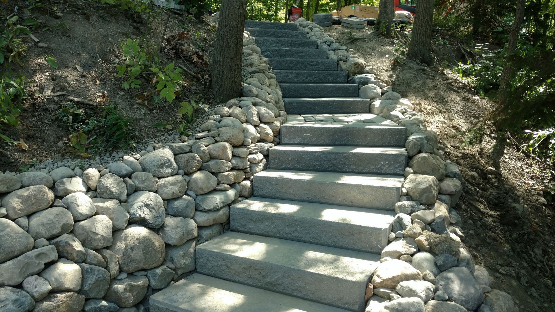 A set of stairs leading up to a stone wall in the woods