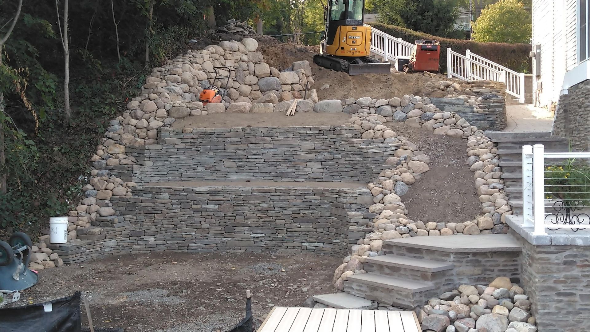 A large pile of rocks is being built in front of a house