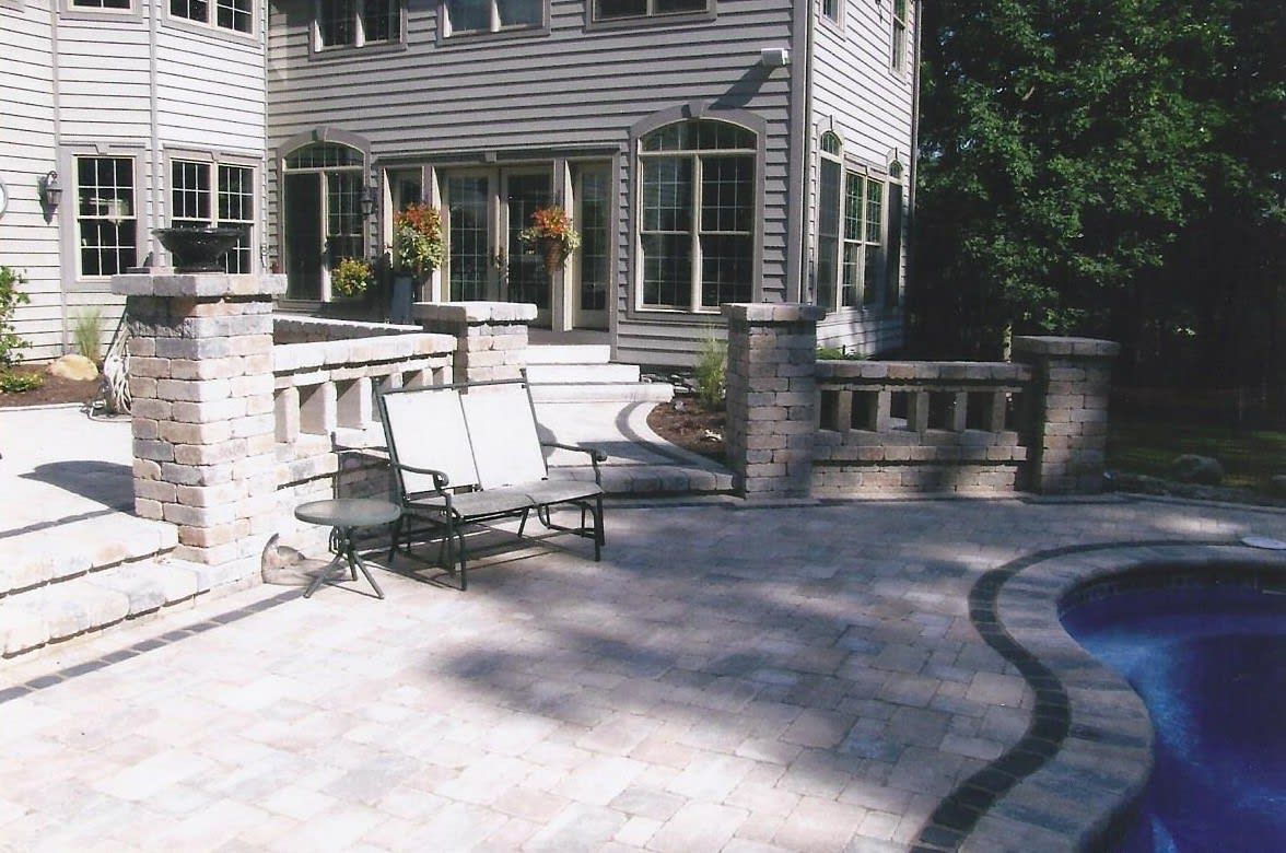 A house with a patio and a pool in front of it