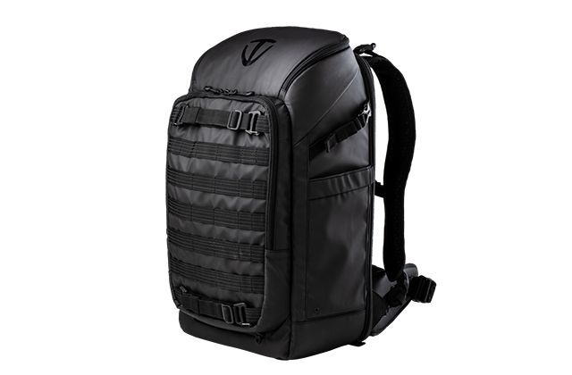 A black backpack is sitting on a white surface.