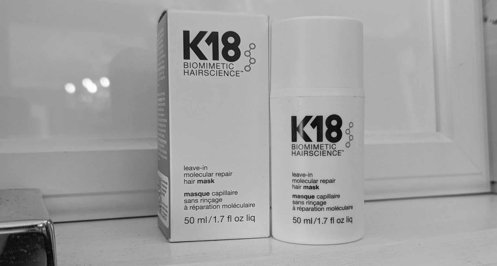 Two bottles of k18 are sitting next to each other on a counter.