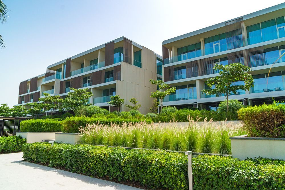 A large apartment building with lots of windows and trees in front of it.
