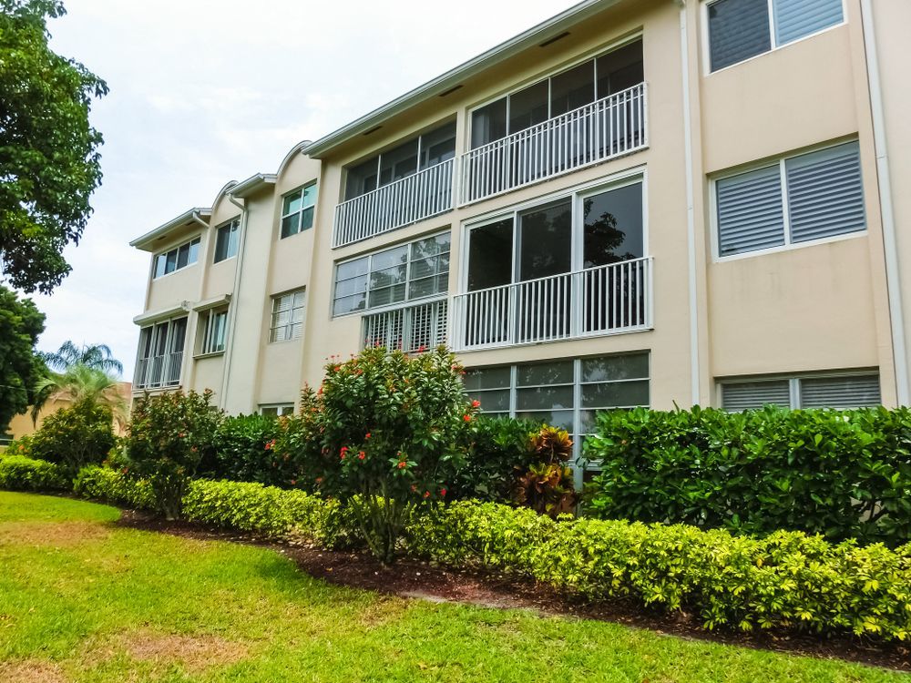 A large apartment building with lots of windows and a screened in balcony