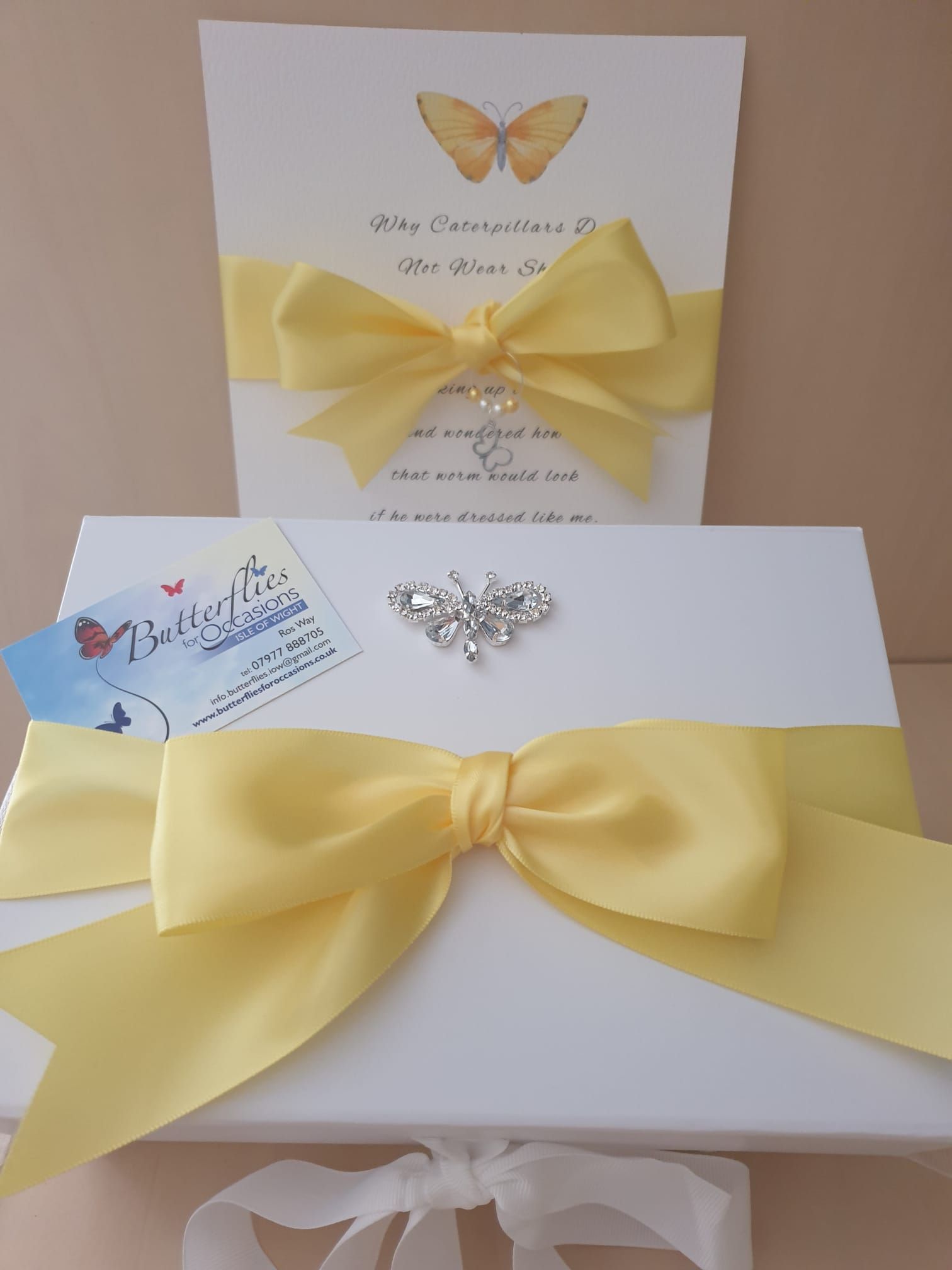 White gift box and invitation card with yellow ribbon bows and butterfly embellishments.