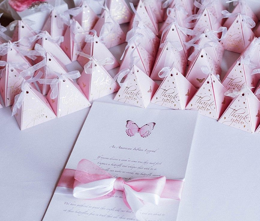 Pink pyramid favor boxes and invitation card with butterfly.