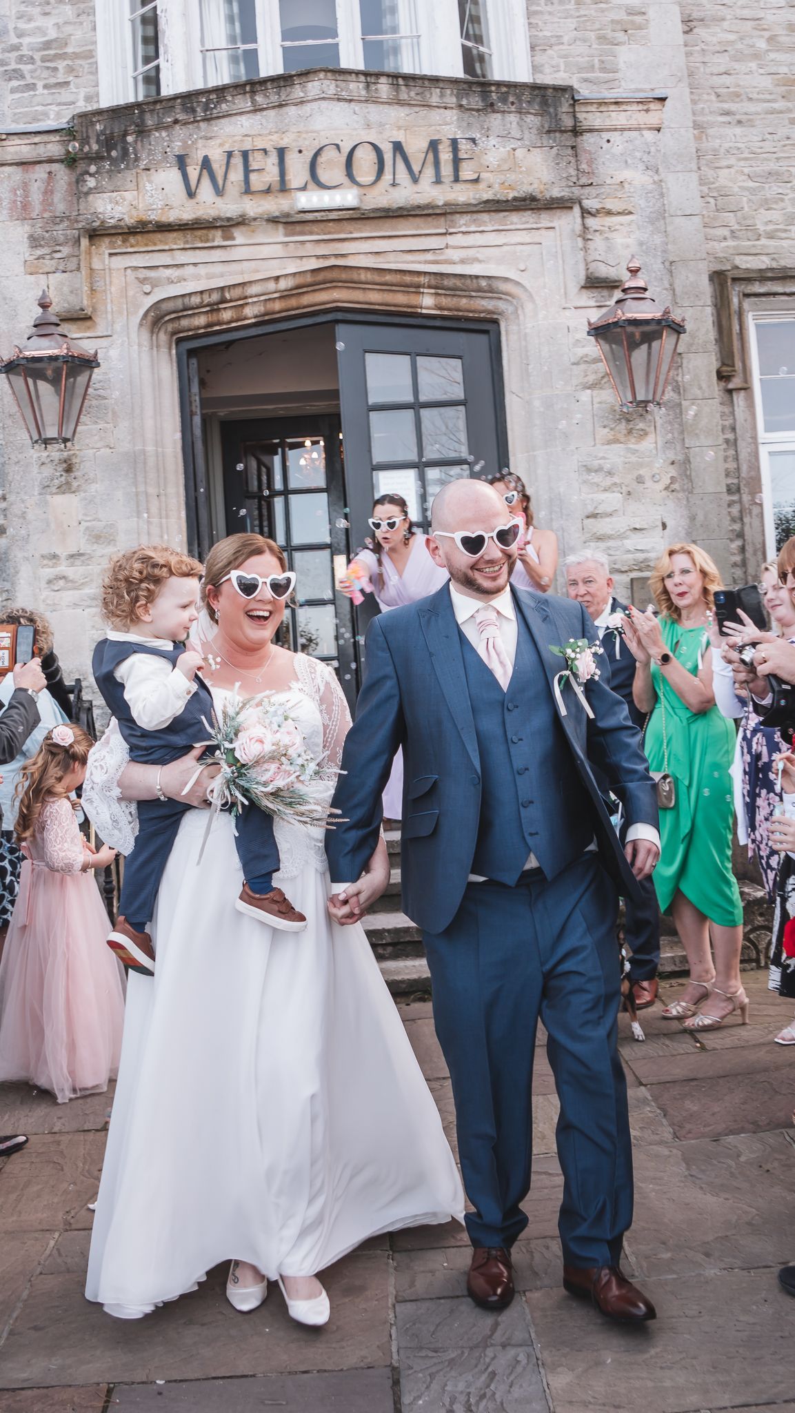 Newlyweds and child exit a building with