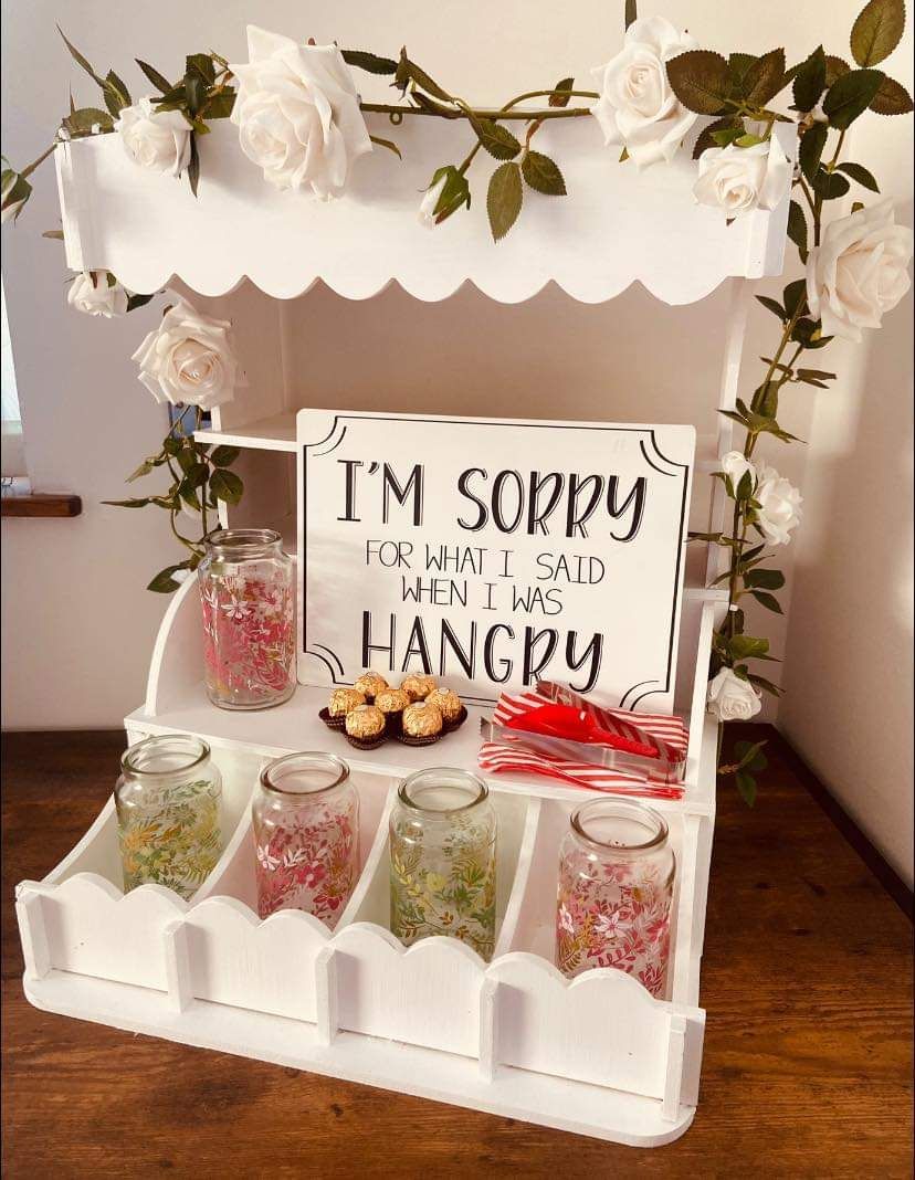 White snack cart with jars of treats, a sign reading