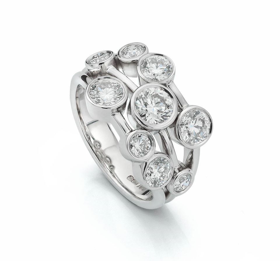 Diamond cluster ring in white metal, featuring multiple round-cut stones.