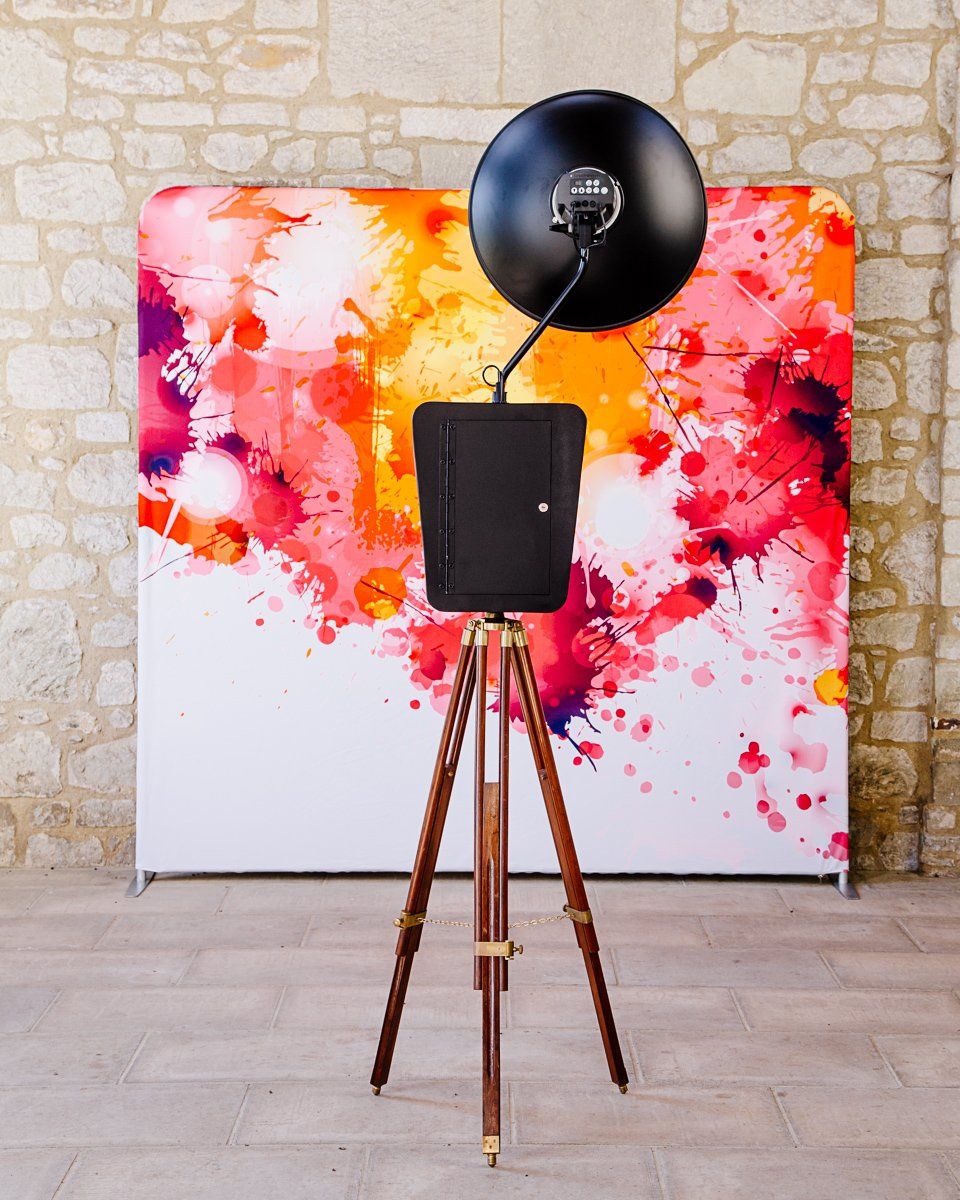 Photo booth on tripod with abstract colorful backdrop.