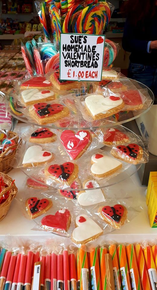 Display of heart-shaped Valentine's shortbread cookies, lollipops and candy canes at a shop.