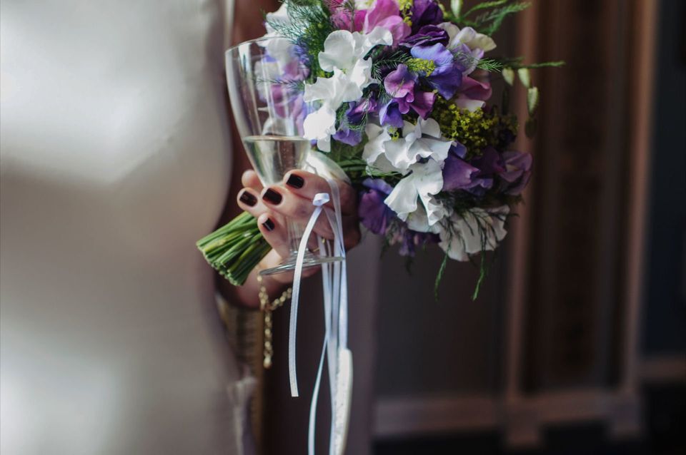 Bride holding her bouquet and a glass of bubbly