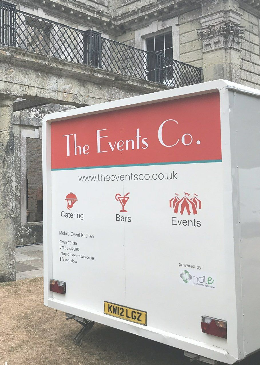 White trailer for The Events Co. in front of a stone building with 