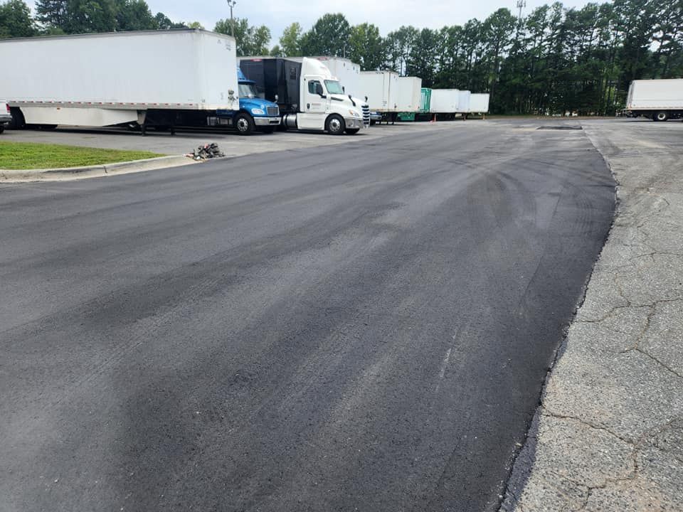 A row of semi trucks are parked in a parking lot