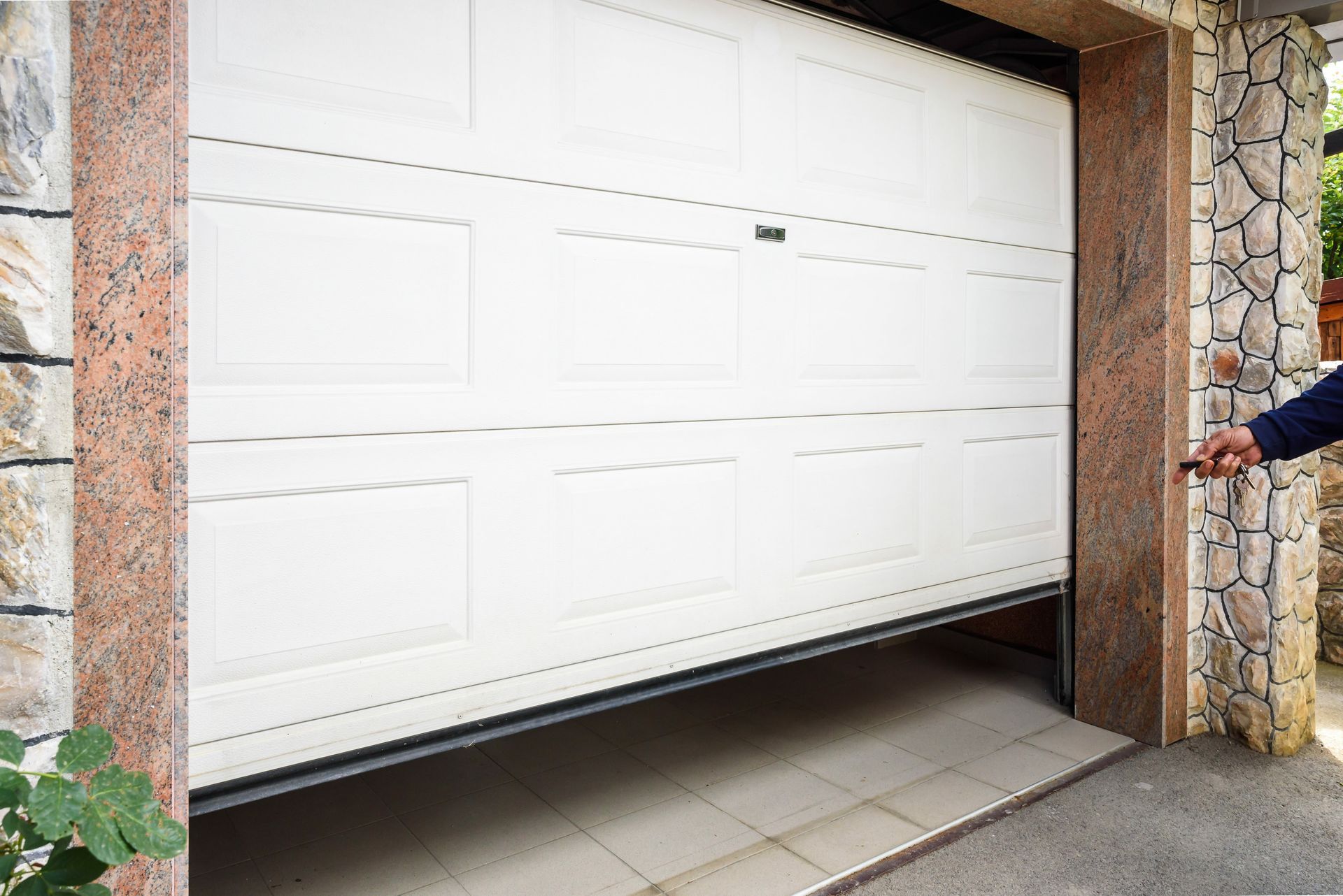 Man using remote, showcasing garage door installation service and modern garage door.