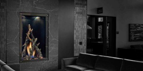 Modern fireplace with burning flames surrounded by stone walls in a dark-toned living room.