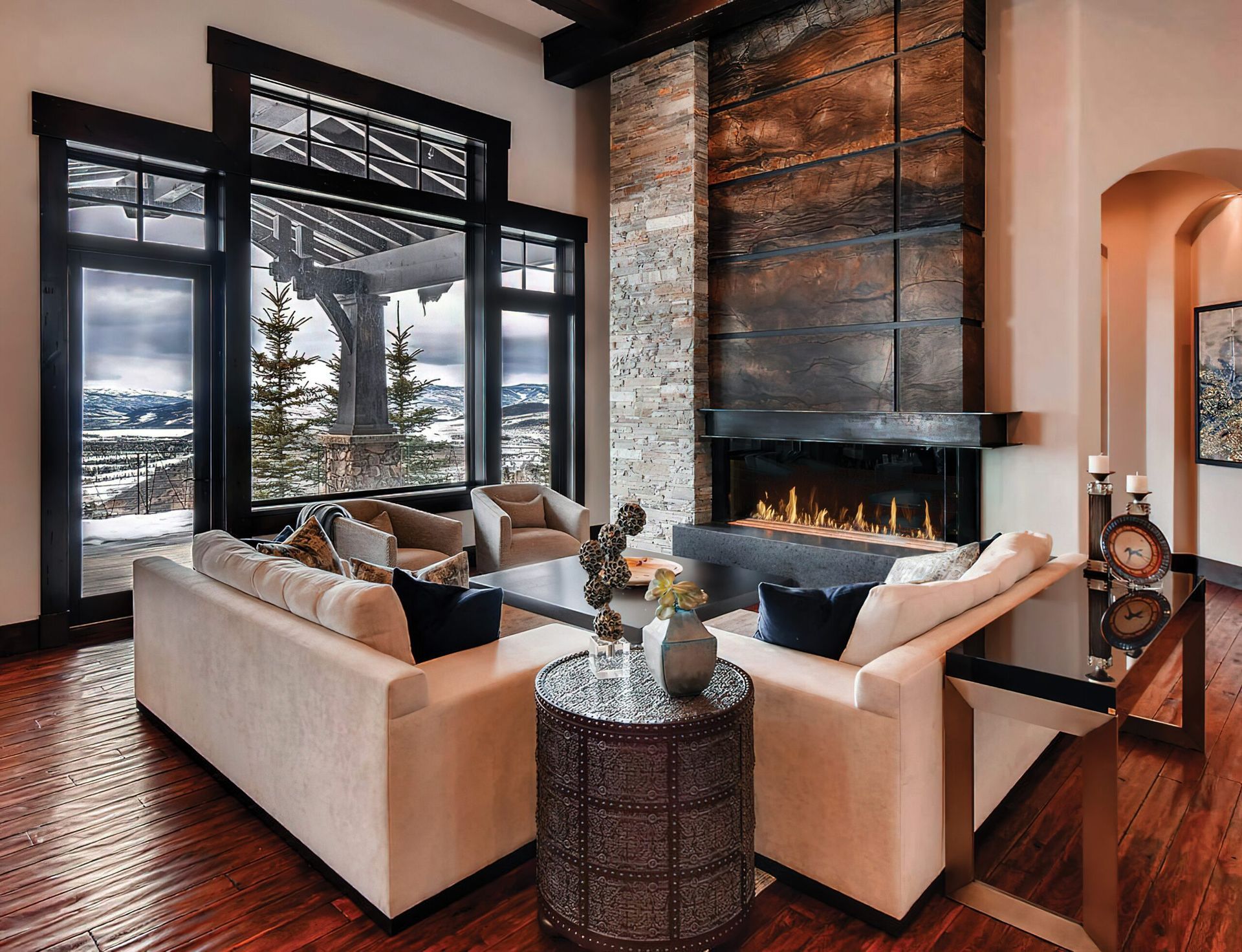 Living room with fireplace, sofas, large window overlooking snowy landscape, dark trim. Living room with fireplace, sofas, large window overlooking snowy landscape, dark trim.