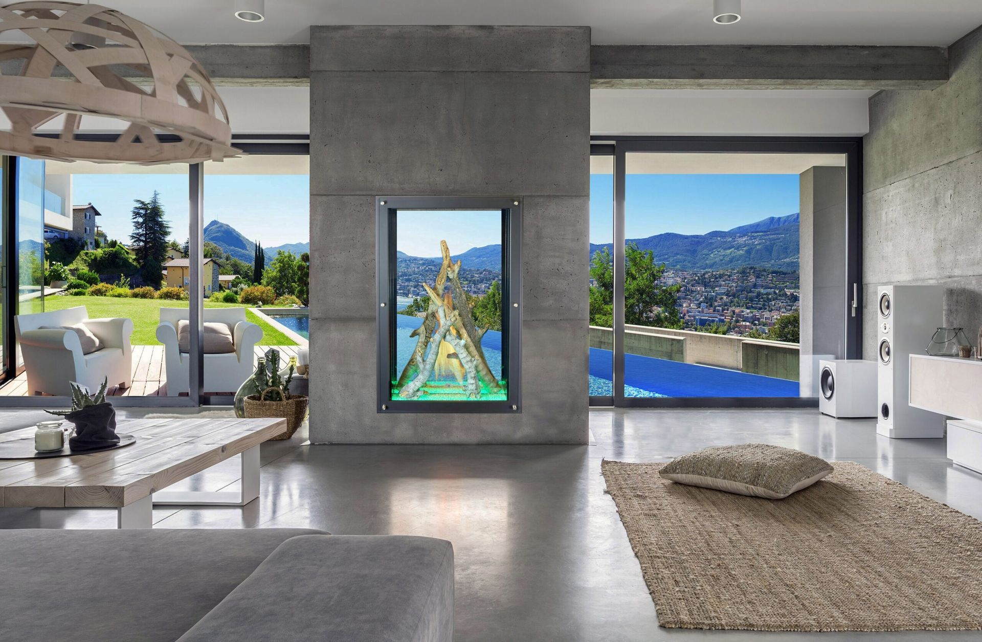 Modern living room with large windows, mountain view, and built-in screen displaying nature scene.