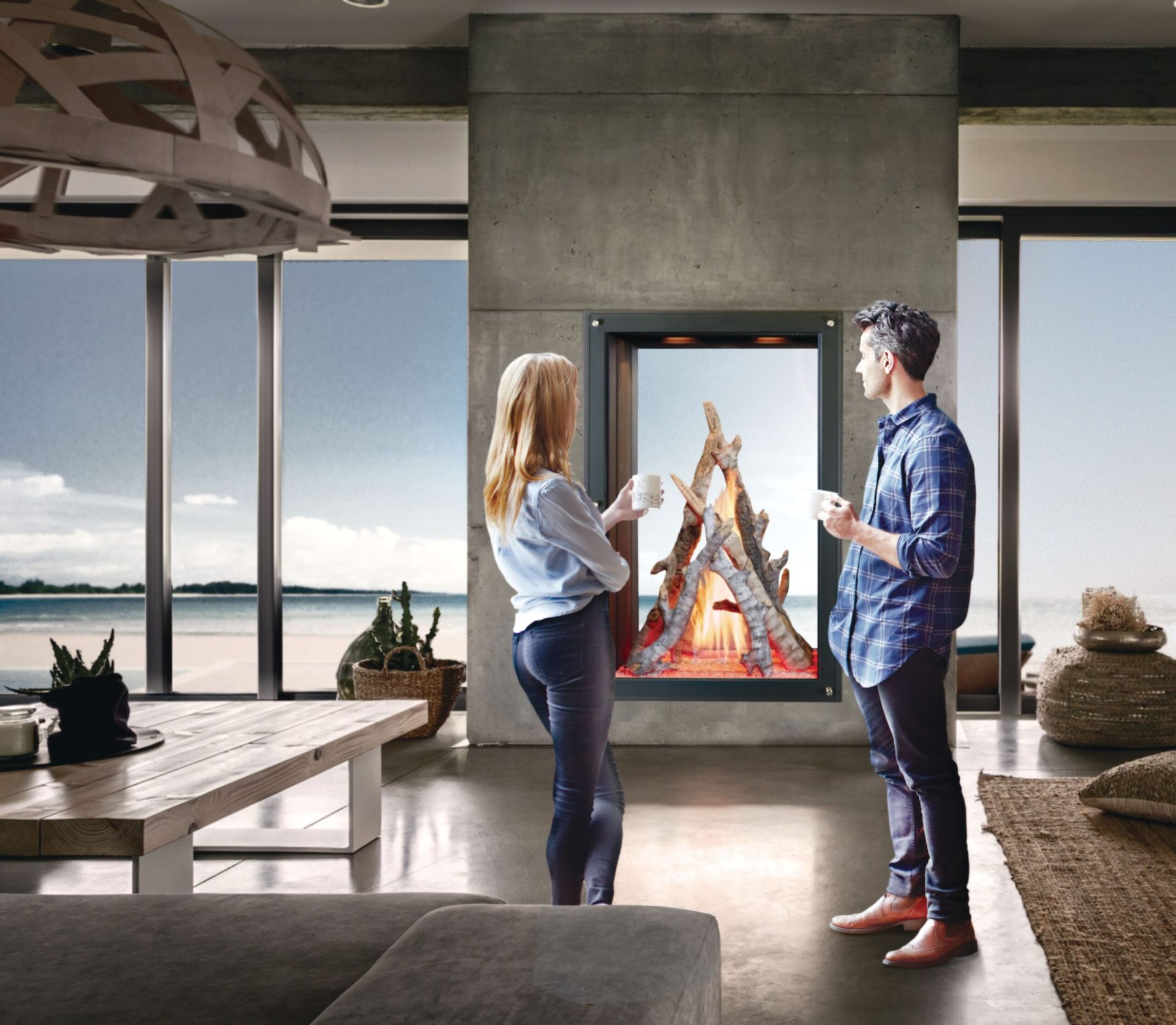 Couple standing before a modern fireplace with a simulated fire, ocean view visible.
