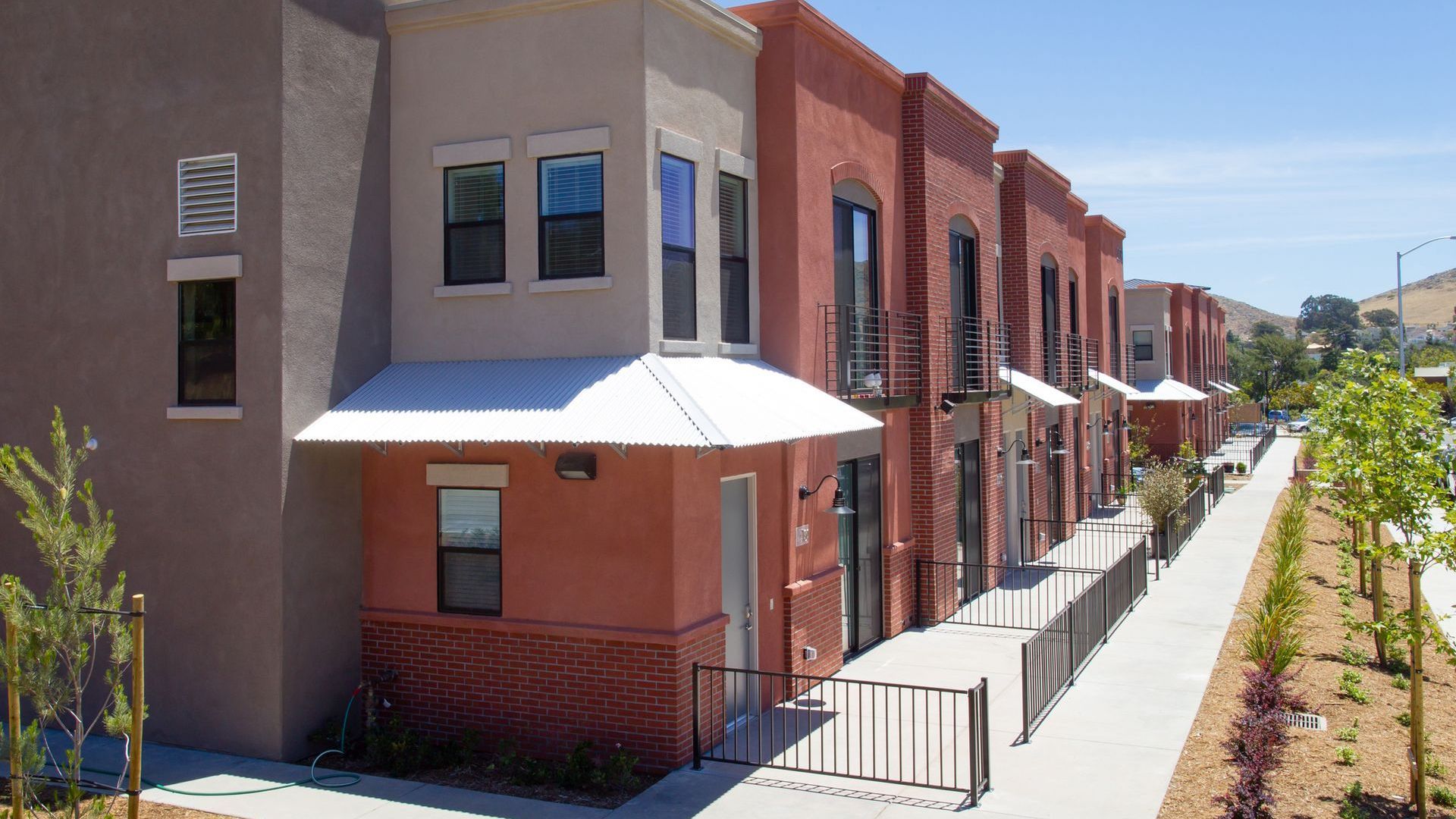 A row of apartment buildings with a walkway between them