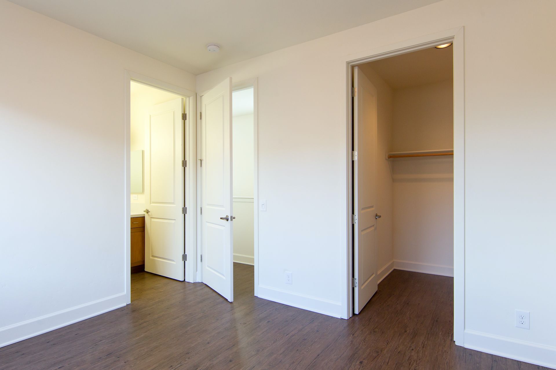 An empty bedroom with a walk in closet and a bathroom.