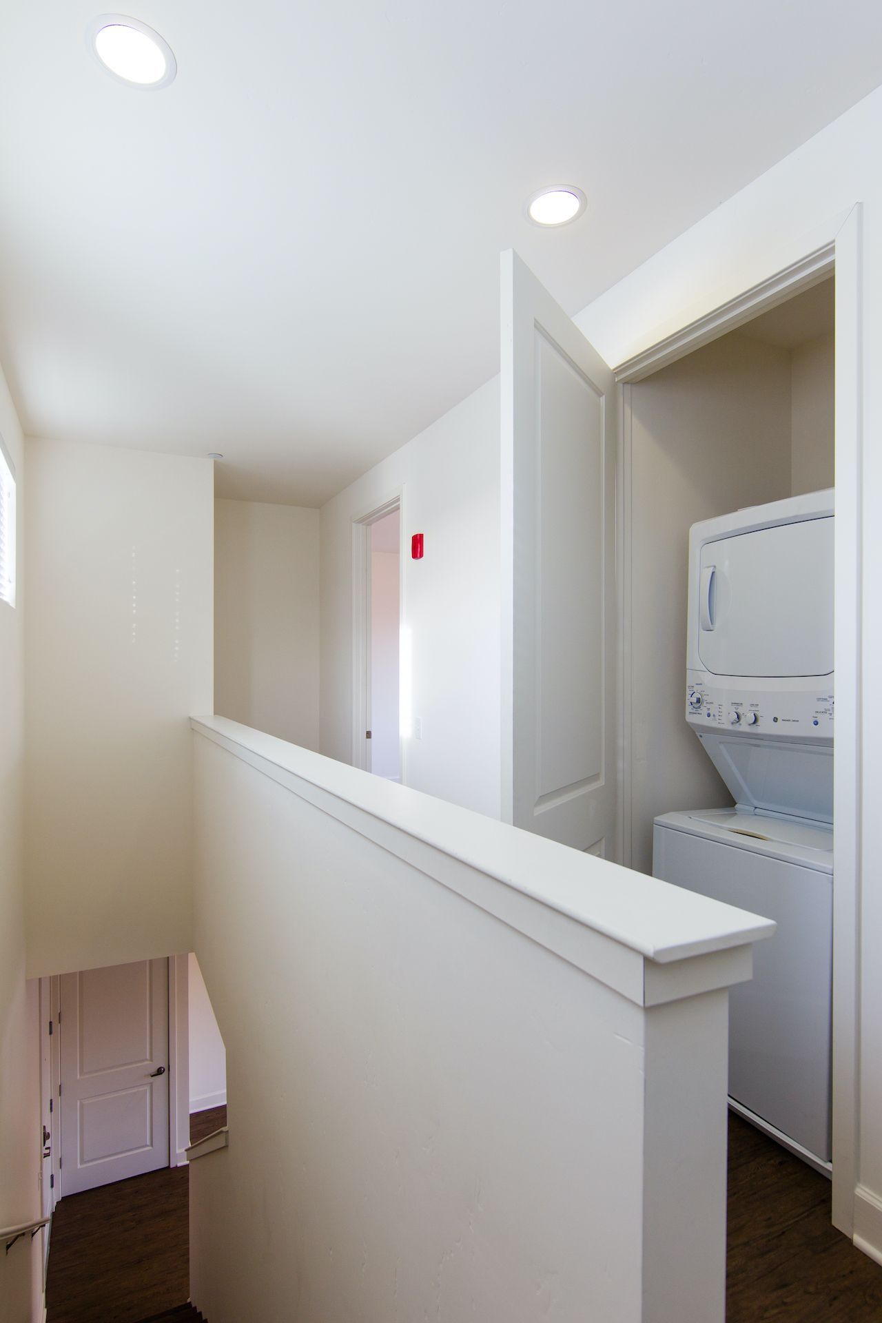 A staircase leading to a laundry room with a washer and dryer.