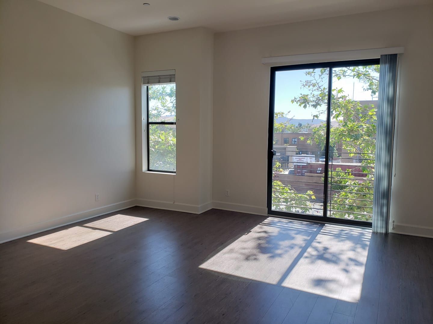 An empty room with a sliding glass door and a window.