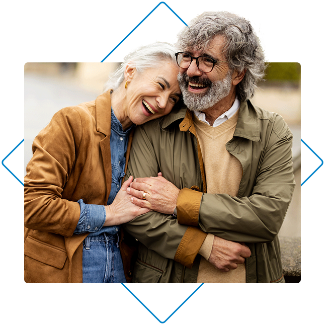 Older couple embracing each other next to a lake