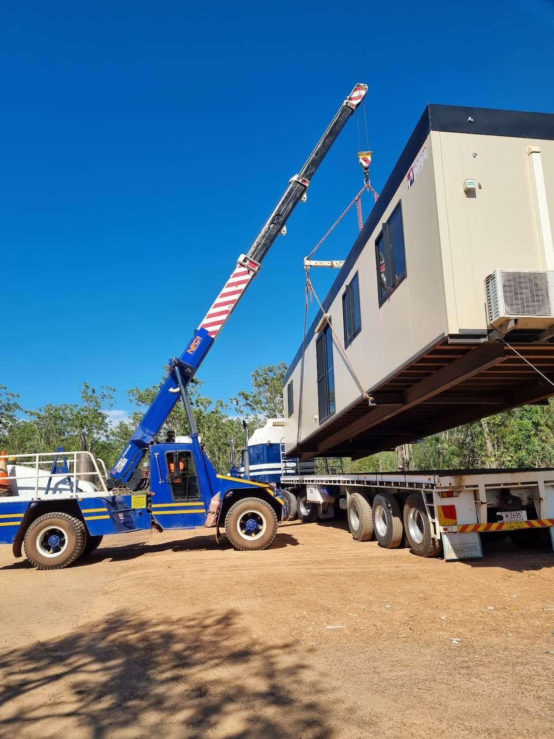 A Crane Is Lifting a Trailer with A Building on It — Northern Franna Cranes NT in Noonamah, NT