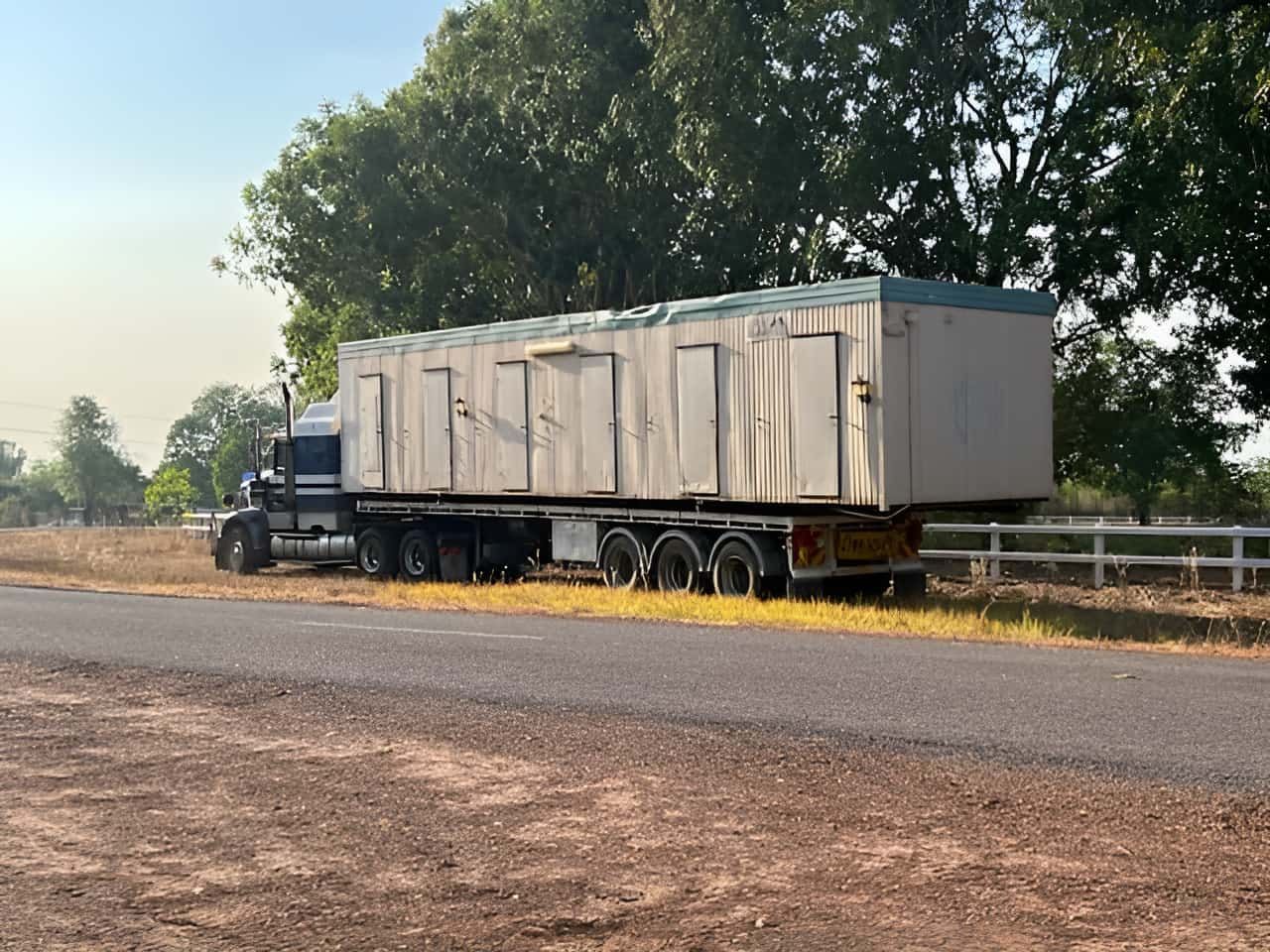 A Semi Truck is Driving Down the Road With a Trailer Full of Containers — Northern Franna Cranes NT in Katherine, NT