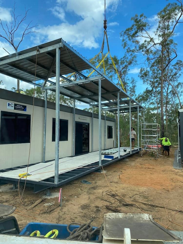 A Crane is Lifting a Roof Over a Building Under Construction — Northern Franna Cranes NT in Palmerston, NT