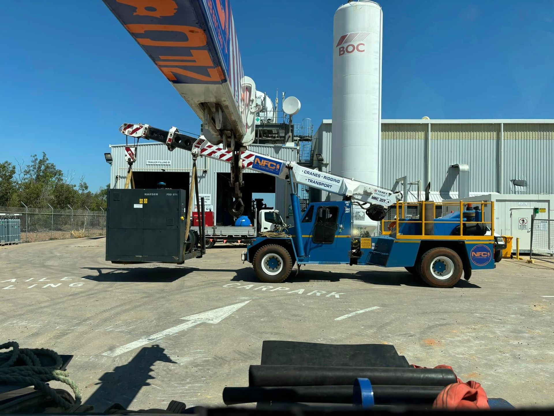 A Crane Lifting Machinery in Front of a Large Factory — Northern Franna Cranes NT in Mcarthur River, NT