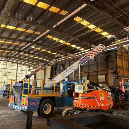 A Crane Is Parked in A Warehouse Next to A Truck — Northern Franna Cranes NT in Noonamah, NT