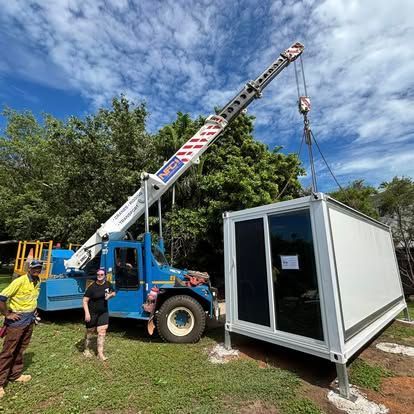 A Man and A Woman Are Standing Next to A Crane Lifting a Container — Northern Franna Cranes NT in Noonamah, NT